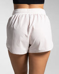 Rear view of light pink women's HIIT shorts with high-rise waistband and no lining.