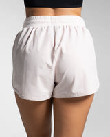Rear view of light pink women's HIIT shorts with high-rise waistband and no lining.
