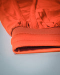 Close-up of stretch waistband of women's gym shorts in cherry red. 