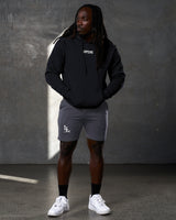 Black hoodie paired with grey LYFT shorts and sneakers in a standing pose.