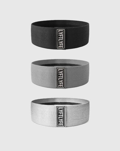 Set of three LYFTLYFE glute resistance bands in black, grey, and light grey with logo patch.
