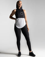 Women’s sleeveless hoodie with two-tone black and white panels, made from performance fabric. 