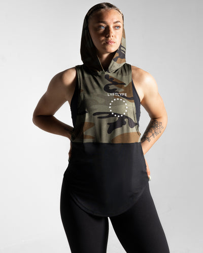 Two-panel women’s sleeveless hoodie in camo and black featuring a long and loose fit with anti-odor and sweat-wicking properties.