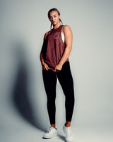 Women’s sleeveless gym tank top in prune, highlighting its lightweight mesh panels and moisture-wicking properties.