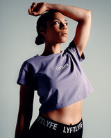 Women’s cropped Drill Tee in purple, featuring a soft crew neckline and premium cover-stitching.
