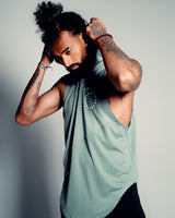 Side view of the Men’s Dominance Sleeveless Hoodie in green, showcasing its breathable fabric and ergonomic fit with a relaxed hood.