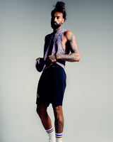 Men’s sleeveless tank top in purple, shown from the side, highlighting lightweight, wrinkle-resistant performance fabric. 