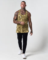 Full body shot of model in green sponge print gym stringer and black joggers. 