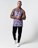 Full body shot of model in purple haze gym stringer and black joggers. 