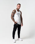 Head-to-toe shot of model wearing white marble gym tank. 