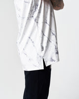 Side seam and flag label close-up on white performance marble tank.