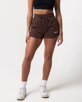 Front view of women’s high-waisted dark brown Balance Shorts featuring an elasticized waistband, drawstring, and side pockets.