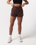 Front view of women’s high-waisted dark brown Balance Shorts featuring an elasticized waistband and tonal drawstring.