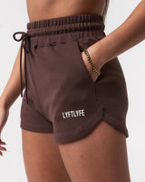 Close-up of women’s Balance Shorts in dark brown, featuring the Lyftlyfe logo, elasticized waistband, and tonal drawstring.