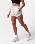 Side angle of women’s light grey sweat shorts with convenient side pockets and premium cotton-polyester fabric.