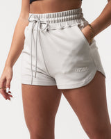 Detailed shot of the side pocket and plush material on women’s light grey Balance Shorts with a white LYFTLYFE logo. 