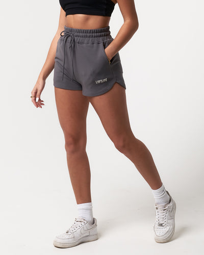 Lightweight dark grey women’s shorts with a high-waisted elasticized waistband and shape-retaining design.