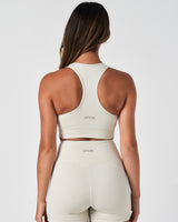 Back view of the Force Bra in Vapor White, featuring a reflective LYFTLYFE logo on the back.