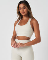 Left side view of the Force Bra in Vapor White, featuring a scoop neckline and minimalist design for medium support.