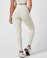 Rear view of Force leggings in off-white featuring minimal logo design and seamless sculpted back.