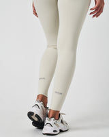 Detailed view of LYFTLYFE reflective logos near ankle cuffs on Force leggings in Vapor White.