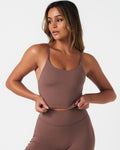 Front view of Force Tank in brown, featuring high neckline, skinny straps, and sculpting fit with built-in bra.