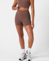 Compressive 4-inch brown biker shorts by LYFTLYFE, shown from the left side with sculpted shape and high stretch.