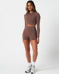 Full body shot of brown Force Crop top, styled with high-waisted shorts for a sleek gym outfit.