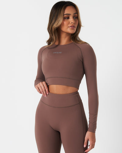 Women’s long sleeve workout crop top in brown, featuring compressive fit and soft 4-way stretch fabric.