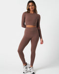 Full body shot of model in Force leggings and matching long sleeve crop top in brown, highlighting full fit.