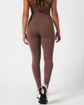 Back profile of high-rise Force leggings in brown, designed for sweat-wicking performance.
