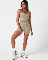 Full body shot of woman in LYFTLYFE Force shorts and matching tank in light green.