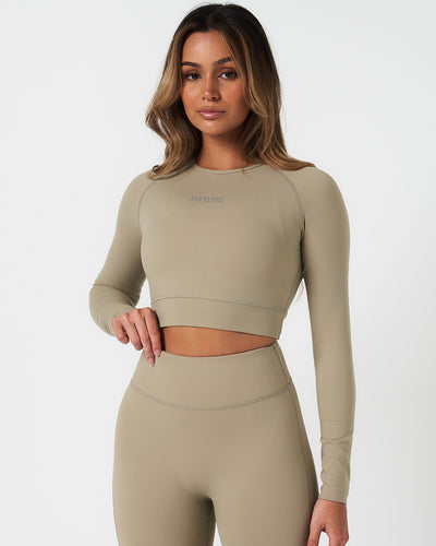 Women’s long sleeve workout crop top in light green, featuring compressive fit and soft 4-way stretch fabric.