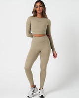 Full-length outfit view showing sculpted leggings paired with matching long sleeve top in light green.