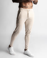 Right side view of Function joggers in beige with LYFTLYFE logo and tapered fit. 