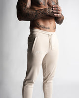 Close-up of LYFTLYFE logo and waistband on beige Function joggers. 