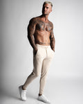 Men’s beige joggers with relaxed fit and front LYFTLYFE branding. 