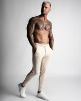 Men’s beige joggers with relaxed fit and front LYFTLYFE branding. 