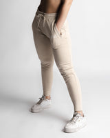 Left side angle of LYFTLYFE React joggers in beige showing tapered leg and pocket detail. 
