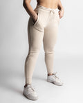 Right side angle of LYFTLYFE React joggers in beige showing tapered leg and pocket detail. 
