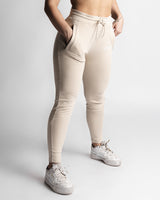 Right side angle of LYFTLYFE React joggers in beige showing tapered leg and pocket detail. 
