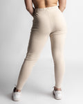 Back view of women’s joggers in beige, sculpted athletic fit.