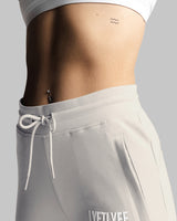Close-up of Elastic waistband and drawcord detail on LYFTLYFE women's joggers in light grey. 
