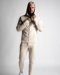 Full-body athletic look in Function hoodie and joggers zipped up in matching sand color. 