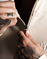 Close-up of hand zipping up LYFTLYFE men's function hoodie showcasing premium zipper and 3D logo detail.