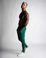Men's athletic joggers in dark green with minimalist design and logo. 
