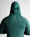 Close-up of “Dominate Adversity” slogan printed on green hoodie back seam.