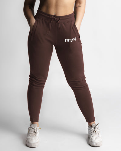 Women’s dark brown joggers front view with high waist and white LYFTLYFE logo. 