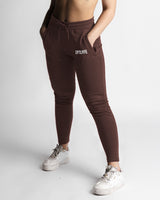 Dark brown joggers left side view showing snug waistband and ankle taper. 