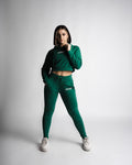 Woman wearing green cropped hoodie and joggers, standing pose showing full tapered fit. 